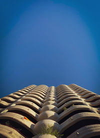 Low angle view of modern building against clear blue sky