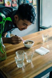 Young man preparing coffee on table