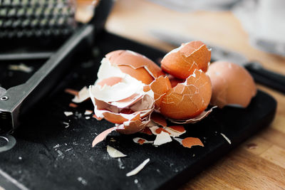 High angle view of broken brown eggshells on cutting board