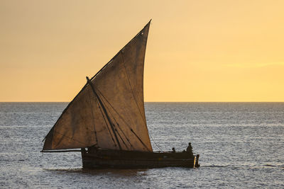 Sailboat on sea against clear sky during sunset