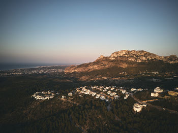 Scenic view of sea by buildings against clear sky