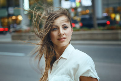 Close-up of beautiful woman standing on street in city