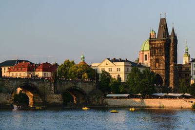 Arch bridge over river against buildings in city