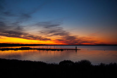 Scenic view of lake against orange sky