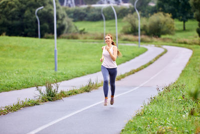 Full length of woman with umbrella on road