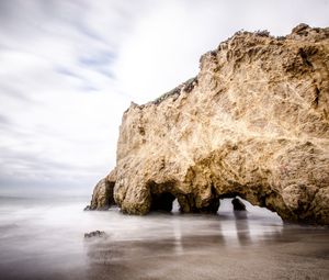 Rock formations by sea against sky