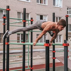 Side view of young woman exercising in city