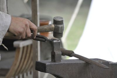 Cropped hands of man working on metal in workshop