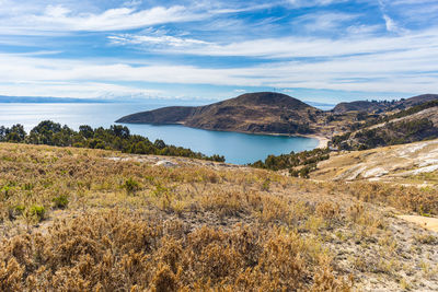 Scenic view of sea and mountains against sky