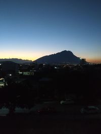 Illuminated city against sky at dusk