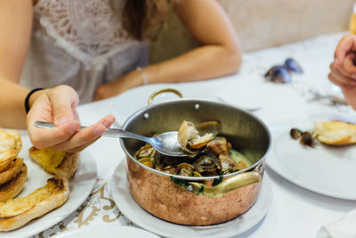 Midsection of woman eating seafood at table