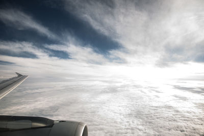 Airplane flying over cloudscape against sky