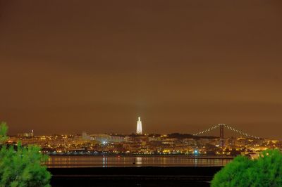 Illuminated cityscape against sky at night