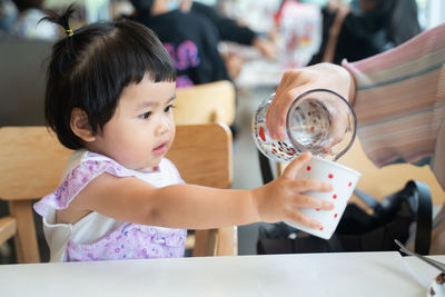 Cute girl holding food on table