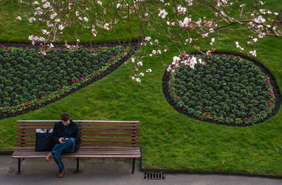 Woman sitting on bench in park