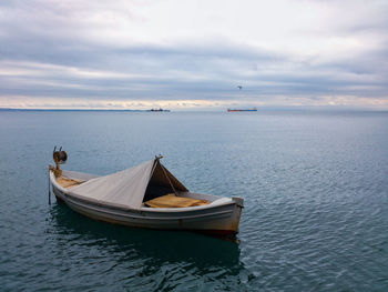 High angle view of boat moored in sea against cloudy sky