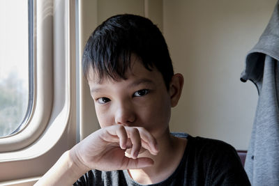 Portrait of boy looking through window