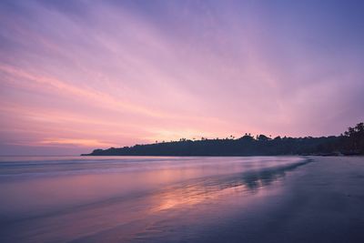 Scenic view of beach against romantic sky during sunset