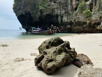 Rock formations on beach against sky