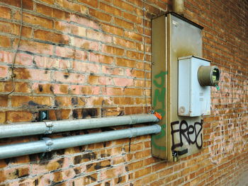 Close-up of fuse box on abandoned brick wall