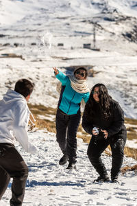 Laughter echoes as this latinofamily enjoys  playful snowball fight amidst stunning snowy landscape 