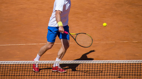 Low section of man playing tennis