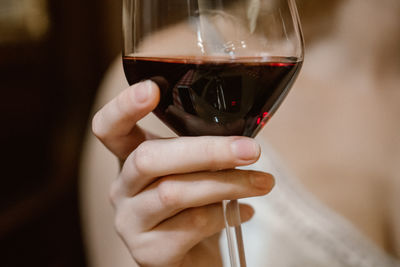 Close-up of hand holding red wine  glass