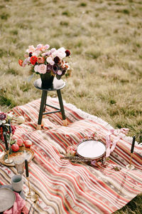 Flowers arranged on blanket at field