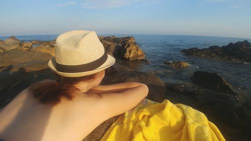 Rear view of woman on beach against sky