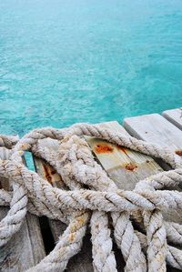 High angle view of rope tied to moored at harbor