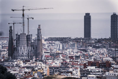 Aerial view of buildings in city against sky