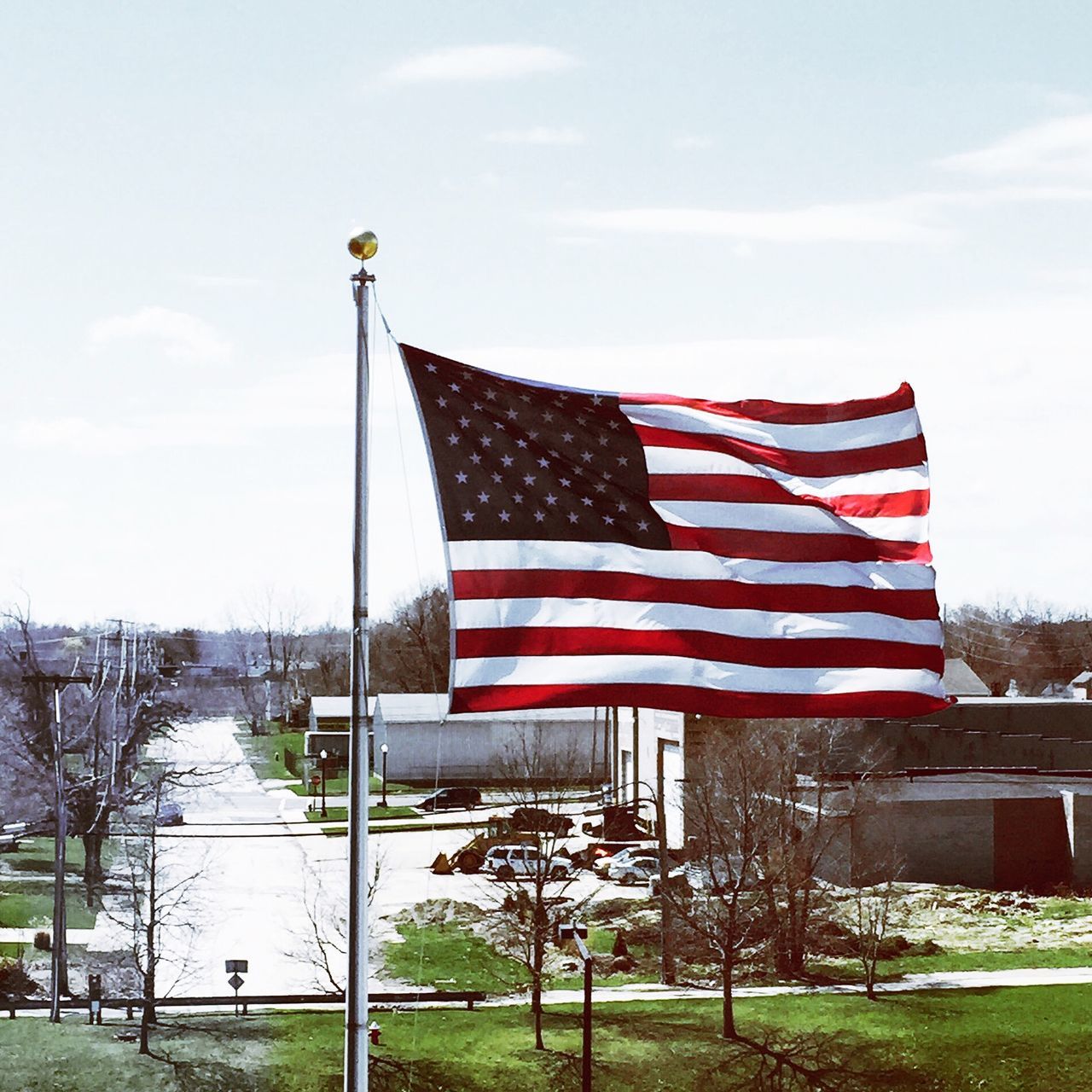 patriotism, flag, national flag, identity, american flag, striped, culture, wind, sky, low angle view, pole, tree, pride, red, flag pole, independence, star shape, waving, day, cloud