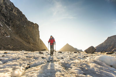 Rear view of people on snow covered mountain against sky