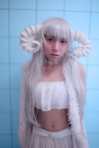 Portrait of a girl standing against wall