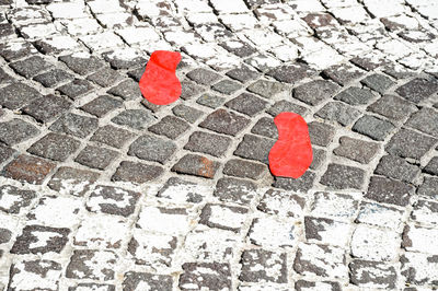 High angle view of red foot markings on footpath