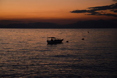 Silhouette boat in sea against sky during sunset