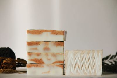 Close-up of soaps stacked against white background