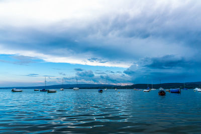 Sailboats in sea against sky