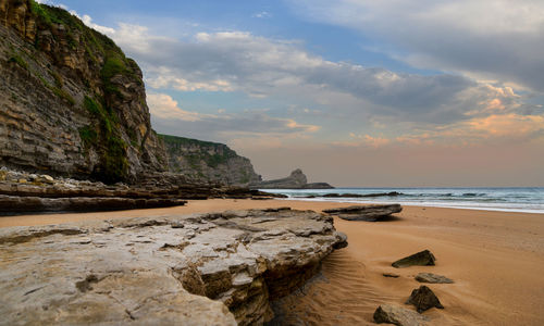 Rocks on beach against sky