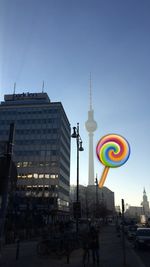 Communications tower in city against clear sky