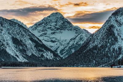 View from the uferstrasse to the plansee in tyrol, austria. romantic sunset behind the mountains.