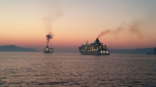 Boat sailing in sea at sunset