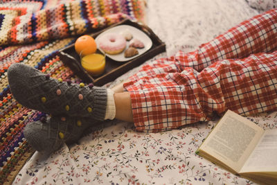 Woman lying on bed having breakfast on holidays. christmas cookies and and donut.  wishes new year