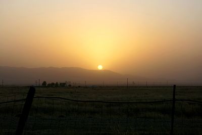 Scenic view of field against sky during sunset