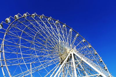 Low angle view of ferris wheel against blue sky