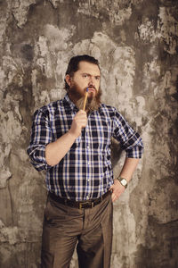 Portrait of man standing against wall