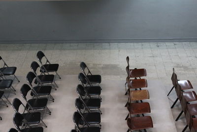 High angle view of chairs arranged by wall