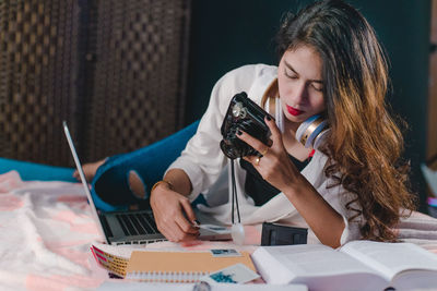 Woman using mobile phone while sitting on table