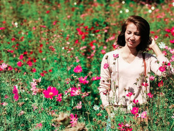 Young woman standing amidst flowering plants