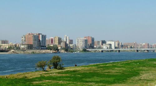 Scenic view of sea by buildings against clear sky